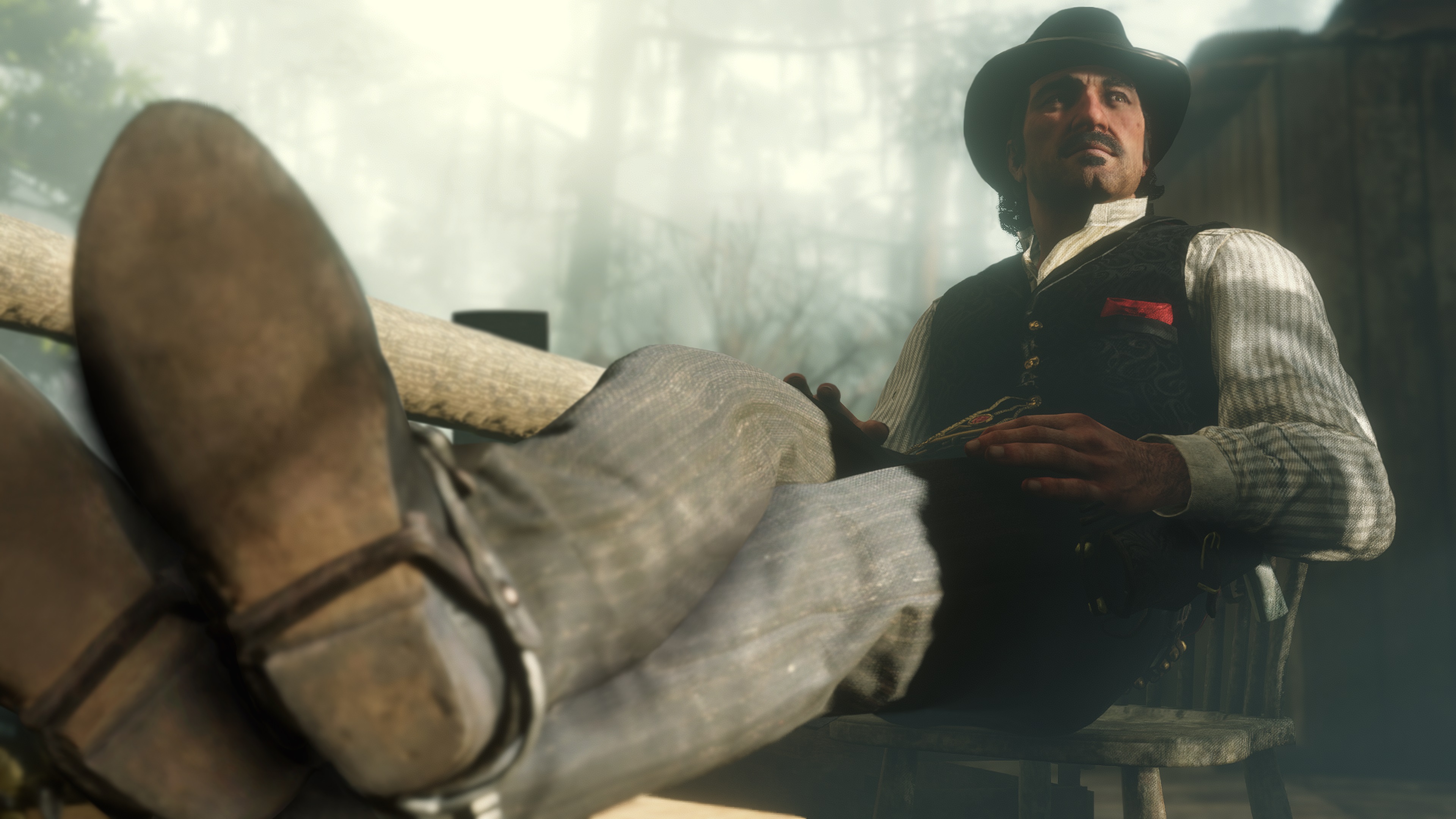 Red Dead Redemption 2 screenshot bandit assis, les pieds sur le bureau