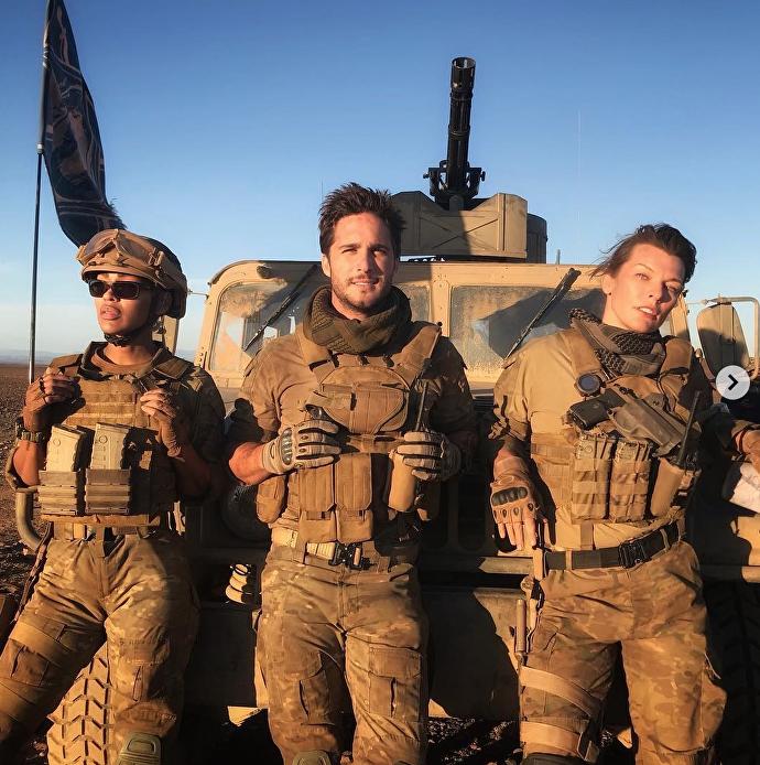 Meagan Good, Diego Boneta et Milla Jovovich addosés à un véhicule militaire